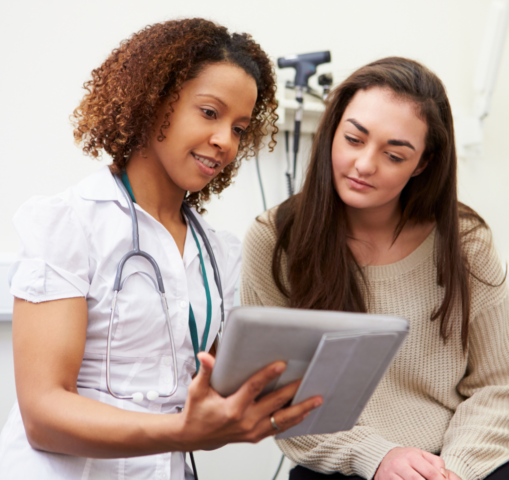 An image of a health care professional going over some paperwork with a patient in a doctor's office